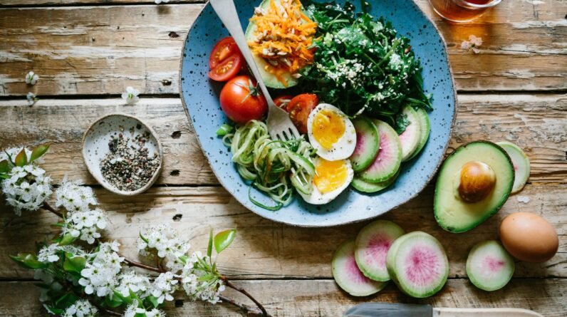 poached egg with vegetables and tomatoes on blue plate